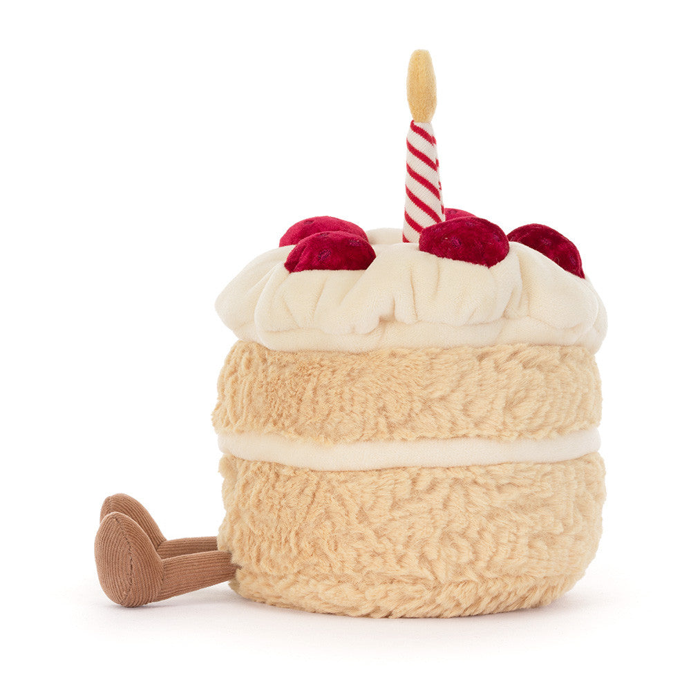 A plush birthday cake toy with textured cream-colored frosting, red velvet-like cherries 