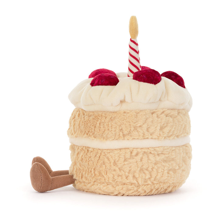 A plush birthday cake toy with textured cream-colored frosting, red velvet-like cherries 