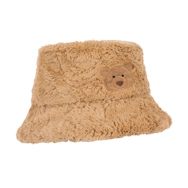 A plush tan bucket hat with a teddy bear face patch on the front, set against a plain white background.