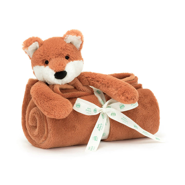Plush fox toy wrapped in a brown blanket with a white ribbon on a white background
