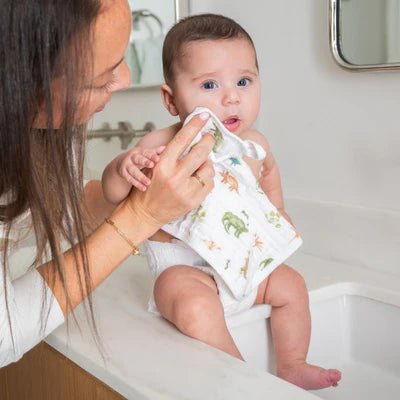 Parent holding baby using Aden + Anais Elephant Circus washcloths