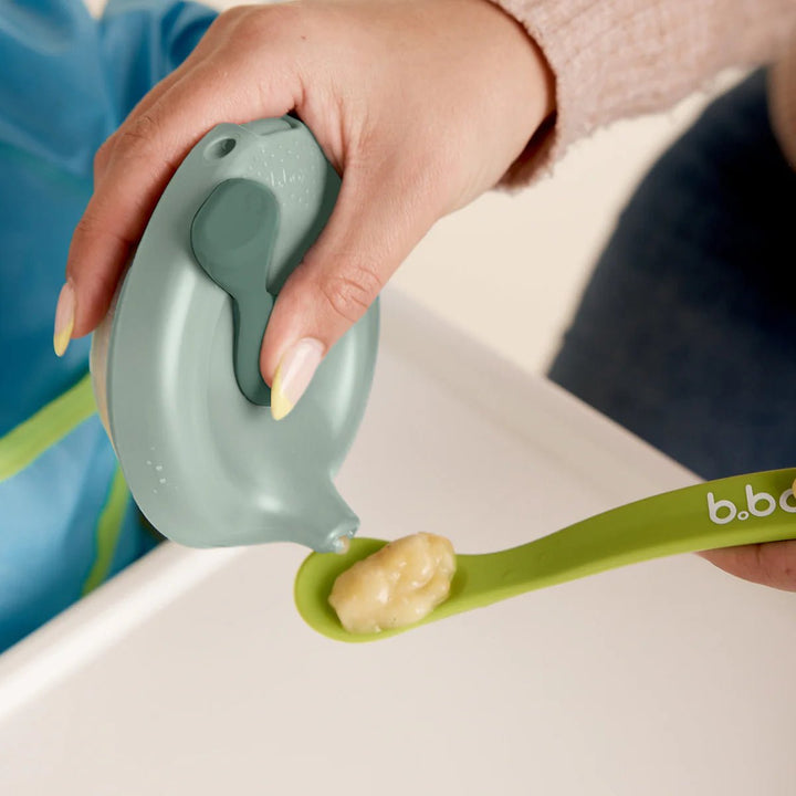 b.box Fill + Feed Storage and Containers Sage -  Green baby spoon with food being held by a hand