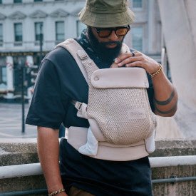 CYBEX Amya Carrier Baby Carriers Almond Beige - Man wearing a beige backpack with a brand logo 