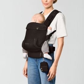 CYBEX LAYA Carrier Baby Carriers Almond Beige - Person using a black baby carrier with a plain background