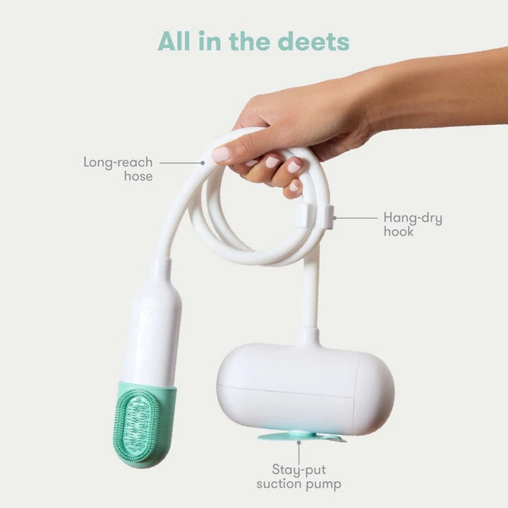 Fridababy - Control the Flow Bath Sprayer - Hand holding a white and green cleaning device with labeled parts  