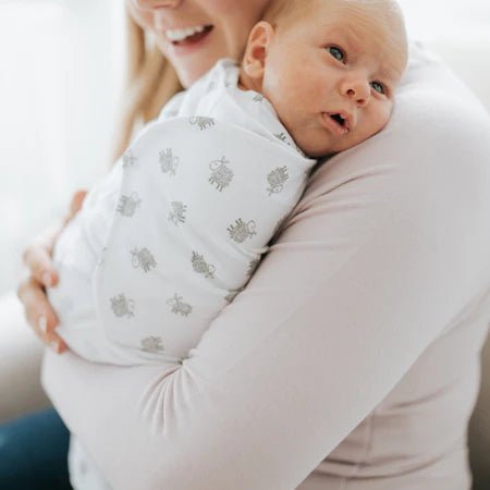 Parent holding baby wrapped in HALO cotton SleepSack Swaddle