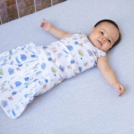 HALO Swaddle 100% Cotton TOG 1.5 SleepSack Swaddle Small with baby wrapped in moon print swaddle blanket