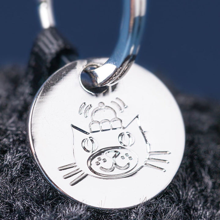 Amuseables Black Hole Bag Charm - Silver cat-shaped pendant on a dark fabric background