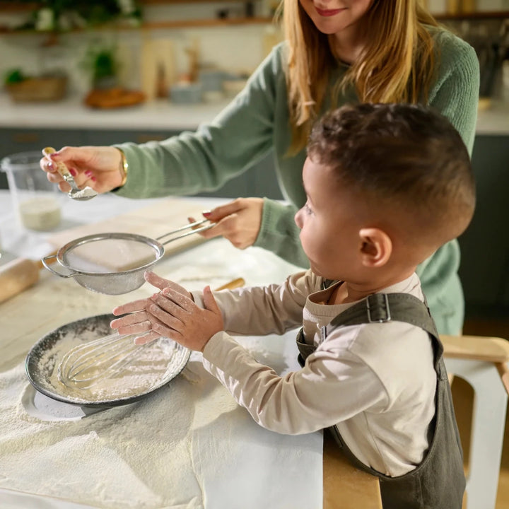 Maxi-Cosi Toucan 3-in-1 Learning Tower helping children safely participate in kitchen activities with caregivers.