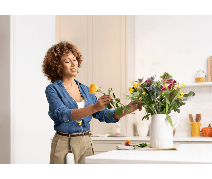Medela Freestyle™ Mini Hands-Free Double Electric Breast Pump Breast Pump  Woman arranging flowers in a kitchen