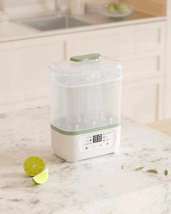 Momcozy 8-in-1 Baby Bottle Steam Sterilizer displayed on a kitchen counter with modern digital control panel.