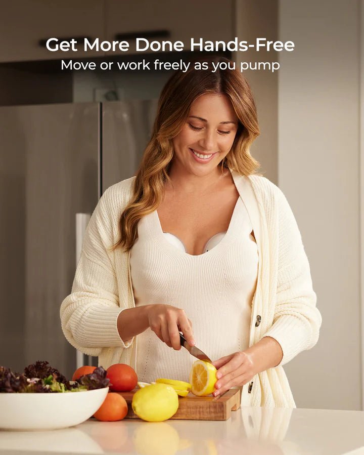 Parent preparing food while wearing the Momcozy M5 Smart Hands-Free Breast Pump for multitasking convenience.