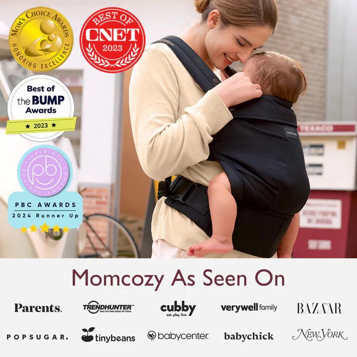 Momcozy Baby Carrier with award-winning ergonomic design worn by a mother carrying her baby comfortably indoors