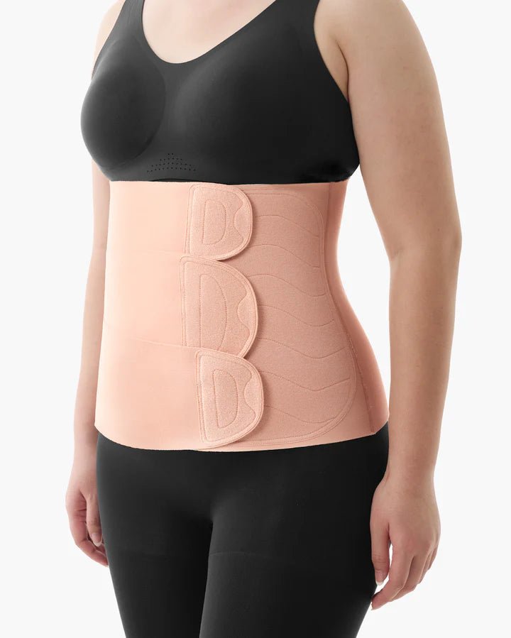 Person wearing the Momcozy Ergowrap Postpartum Belly Wrap with adjustable compression support on white background.