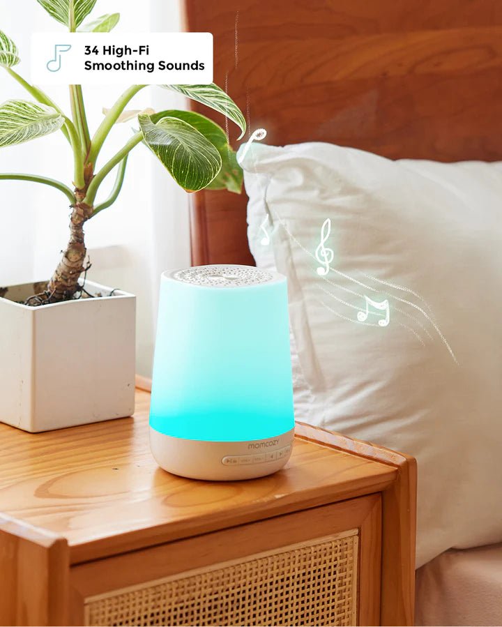 Momcozy Smart Baby Sound Machine glowing on bedside table with relaxing night light for nursery and bedroom use