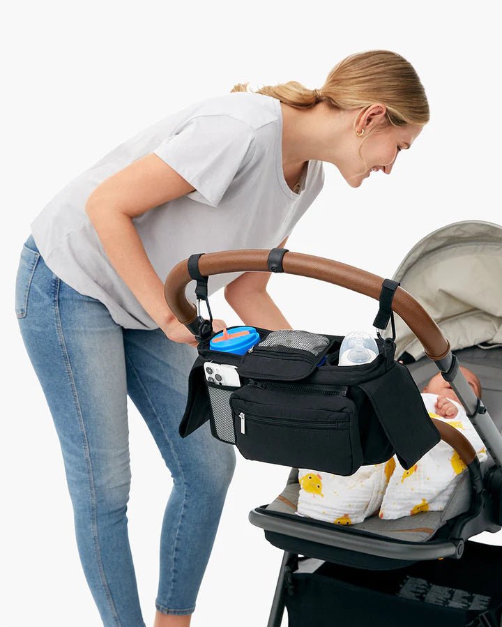 Momcozy stroller organizer attached to a baby stroller with easy-access storage for bottles, phones, and essentials