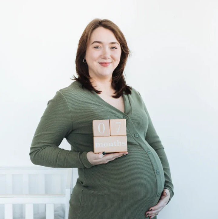 Pearhead - Natural Wooden Milestone Blocks - Pregnant woman holding wooden blocks with numbers 