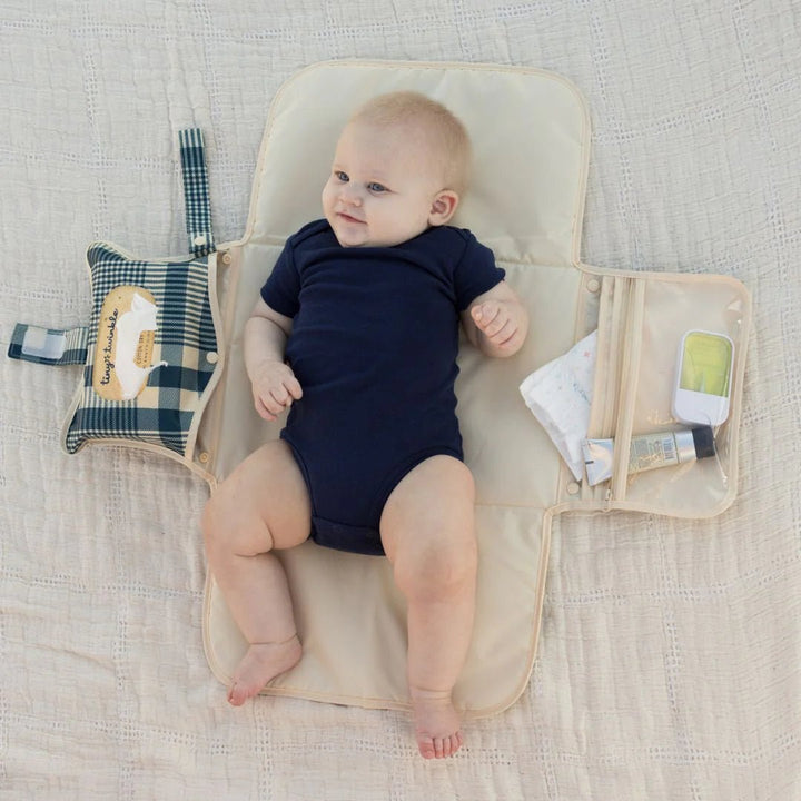 Baby using the Tiny Twinkle portable diaper changing pad with gingham design